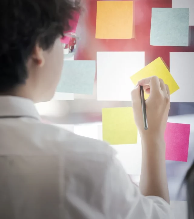 Équipe en réunion autour d’un mur de post-its pour brainstorming